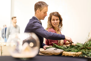 Teilnehmer:innen dekorieren einen Adventkranz beim Adventhock im Festspielhaus Bregenz