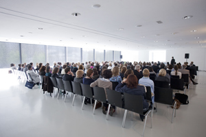 Tagungsteilnehmer:innen im vollbesetzten Saal Bodensee in Reihenbestuhlung im Festspielhaus Bregenz