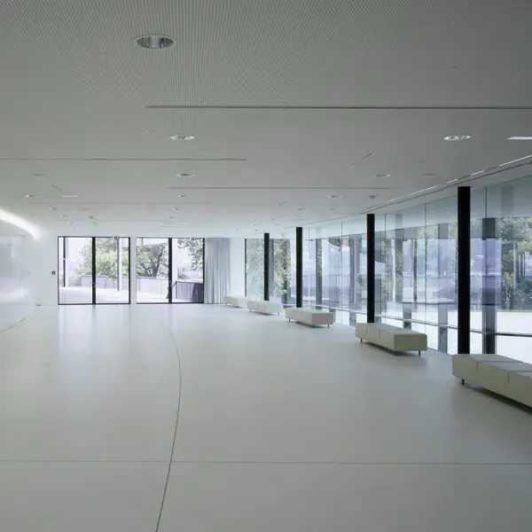 Parkstudio mit weißen Leder-Sitzgelegenheiten entlang der langen Glasfront im Festspielhaus Bregenz © Bruno Klomfar