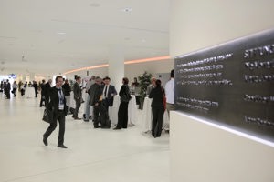 Kongressteilnehmer:innen im weißen Foyer an Stehtischen im Festspielhaus Bregenz