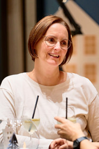 Eine Frau unterhält sich mit Adventhock-Teilnehmer:innen im Seefoyer des Festspielhauses Bregenz