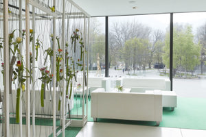 Weiße Lounge-Sitzmöbel mit grünem Teppich und Rosen im Saal Panorama mit Blick auf den Platz der Wiener Symphoniker