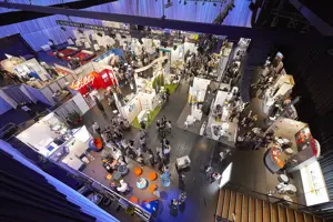 Gutbesuchte Ausstellungskojen auf der blau eingeleuchteten Werkstattbühne im Festspielhaus Bregenz © Anja Koehler