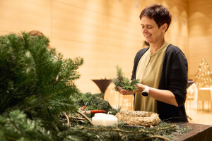 Ein Teilnehmerin hat Freude am Kranzbinden beim Adventhock im Festspielhaus Bregenz