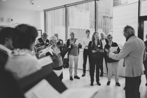 eine Gruppe singender Menschen mit Foyer im Festspielhaus Bregenz
