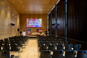 Reihenbestuhlung und Bühne mit Leinwand im verdunkelten Seefoyer im Festspielhaus Bregenz