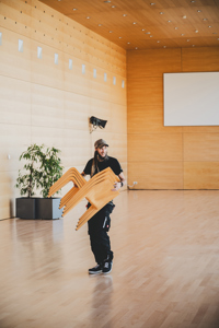 ein Veranstaltungstechniker mit einem Stapel Sühle im Seefoyer des Festspielhauses Bregenz