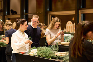 Teilnehmer:innen unterhalten sich beim Adventkranzbinden im Seefoyer im Festspielhaus Bregenz